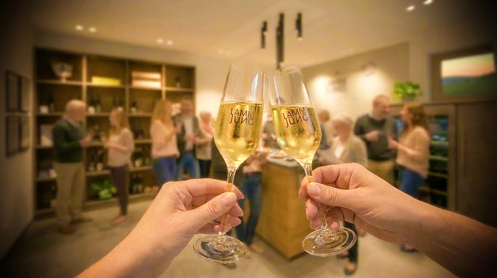 Weinprobe-im-Weingut-lamm-jung-mit-anstossenden-sektglaesern